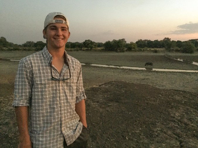 Tyler with a hippo behind him