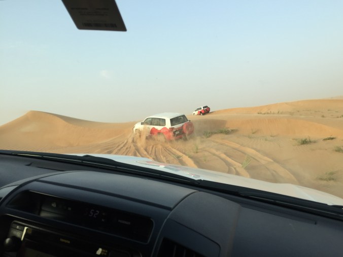 SUVs driving through the dunes